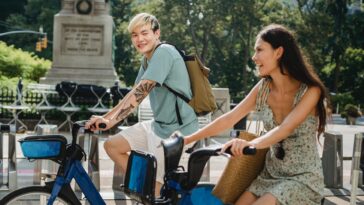 positive multiracial couple riding bicycles and laughing