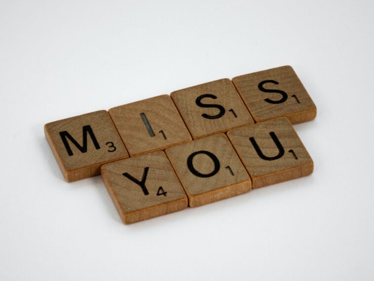 close up shot of scrabble tiles on a white surface with Miss You