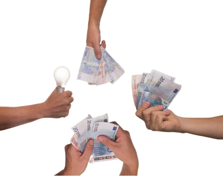a hand holding electricity bob and three hands holding cash