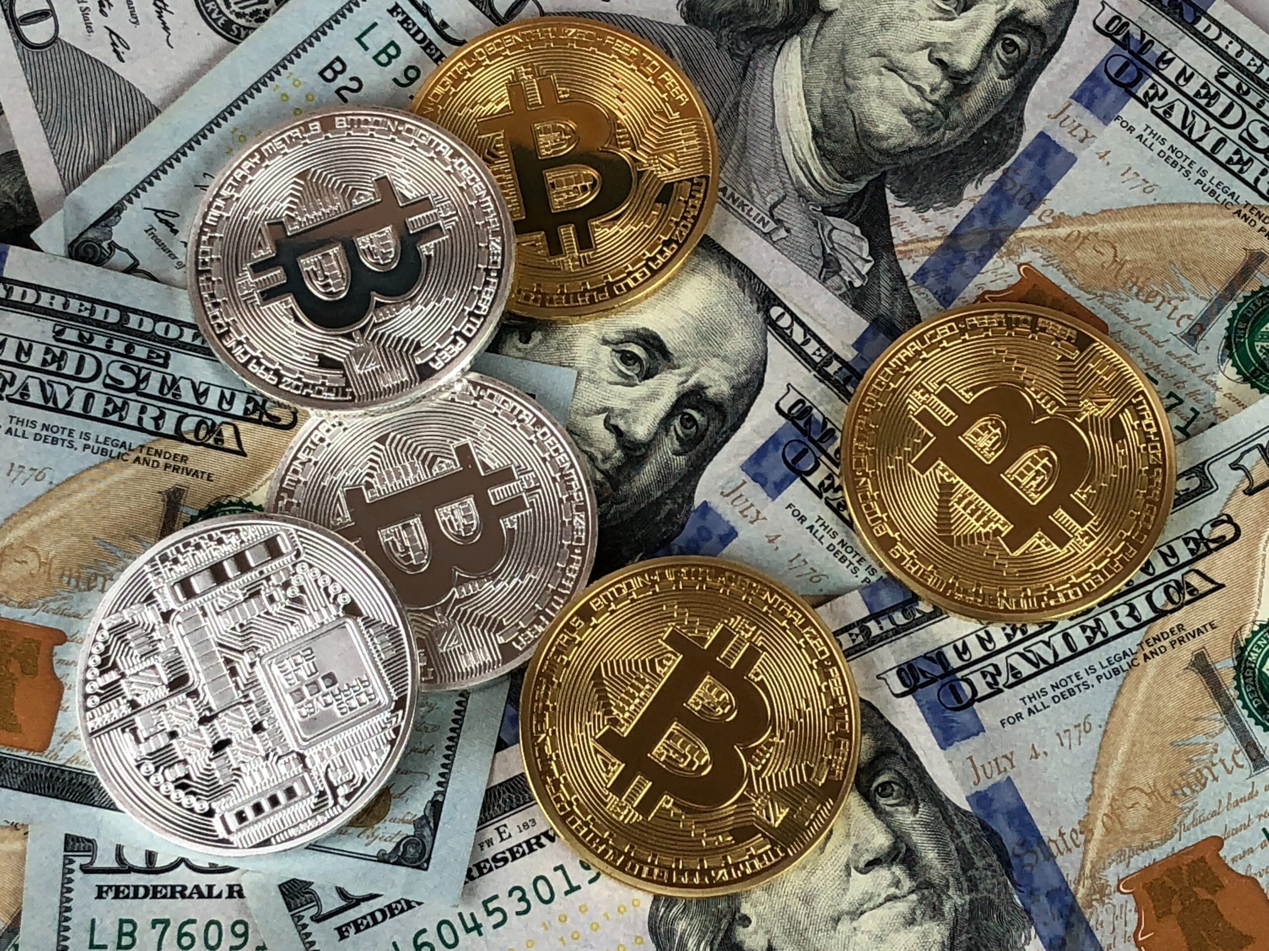 dollar bills, bitcoin and other cryptocurrency coin